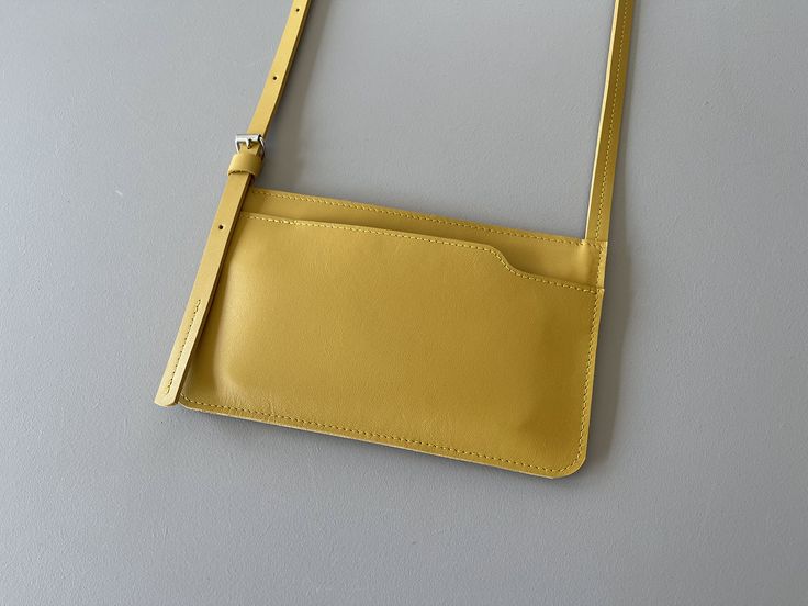 EDGE phone purse is a small leather bag specially made for your phone. For those times when all you need is your phone, key and debit card. Or if you prefer to keep your phone close at hand rather than in that spacious tote bag ;) Then this is the perfect purse in a minimalist style. An item for daily use that looks simple without unnecessary fuss.  width: 20 cm / 7.8 in  height: 12 cm / 4.7 in * front pocket for your phone * back pocket with a zipper for your other essentials or your phone * shoulder strap made of leather and adjustable with a small roller buckle * fits an iPhone 14 Pro Max and any other phone of the same size or smaller will fit * designed & handmade by Marieke Jacobs in the Netherlands This product is made with the greatest care using genuine leather. Because every prod Perfect Purse, Small Leather Bag, Sling Bags, Phone Purse, Minimalist Style, Debit Card, All You Need Is, Minimalist Fashion, The Netherlands