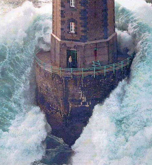 an old lighthouse in the middle of some rough ocean water with waves crashing around it