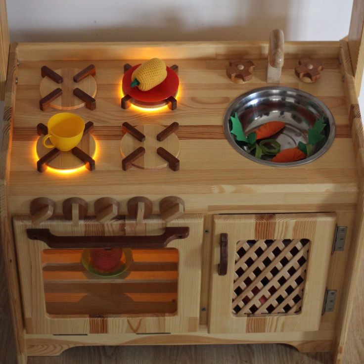 a child's wooden play kitchen with lights on