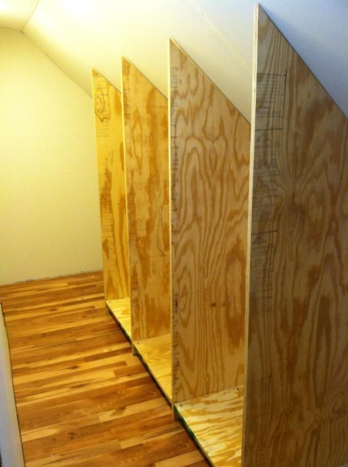 three plywood boards are lined up in the corner of a room with hard wood flooring