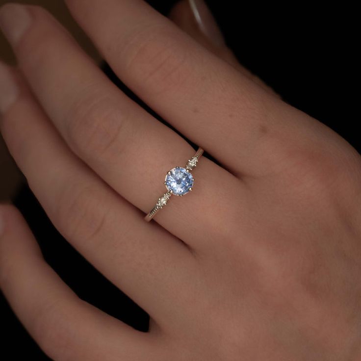 a woman's hand with a ring on it and a diamond in the middle