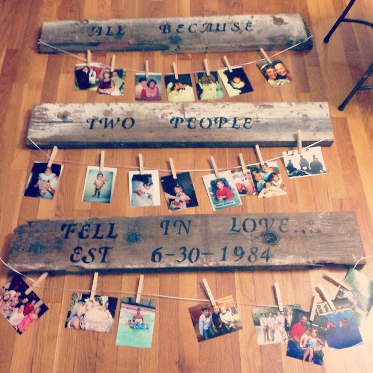 a family tree made out of wooden planks with pictures hanging on clothes pegs