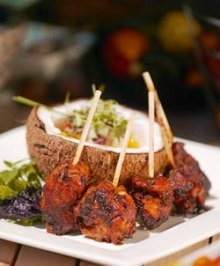 some food is sitting on a white plate with toothpicks in it and garnished with lettuce