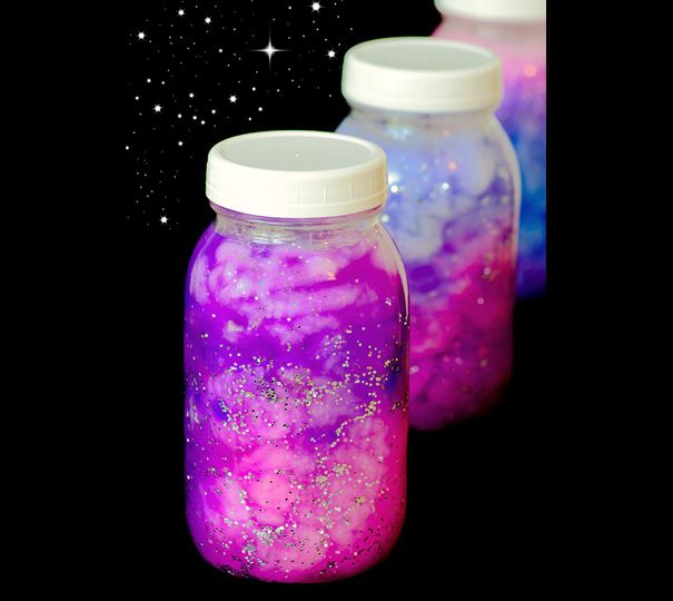 three jars filled with liquid sitting on top of a black surface next to the stars