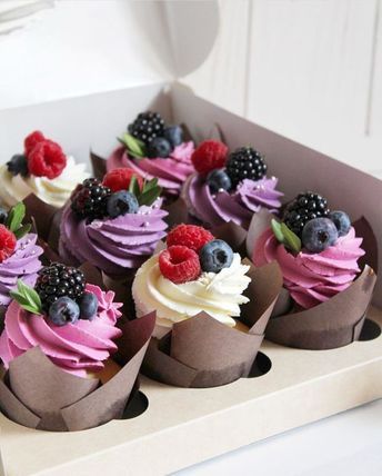 cupcakes decorated with berries, raspberries and blackberries in a box