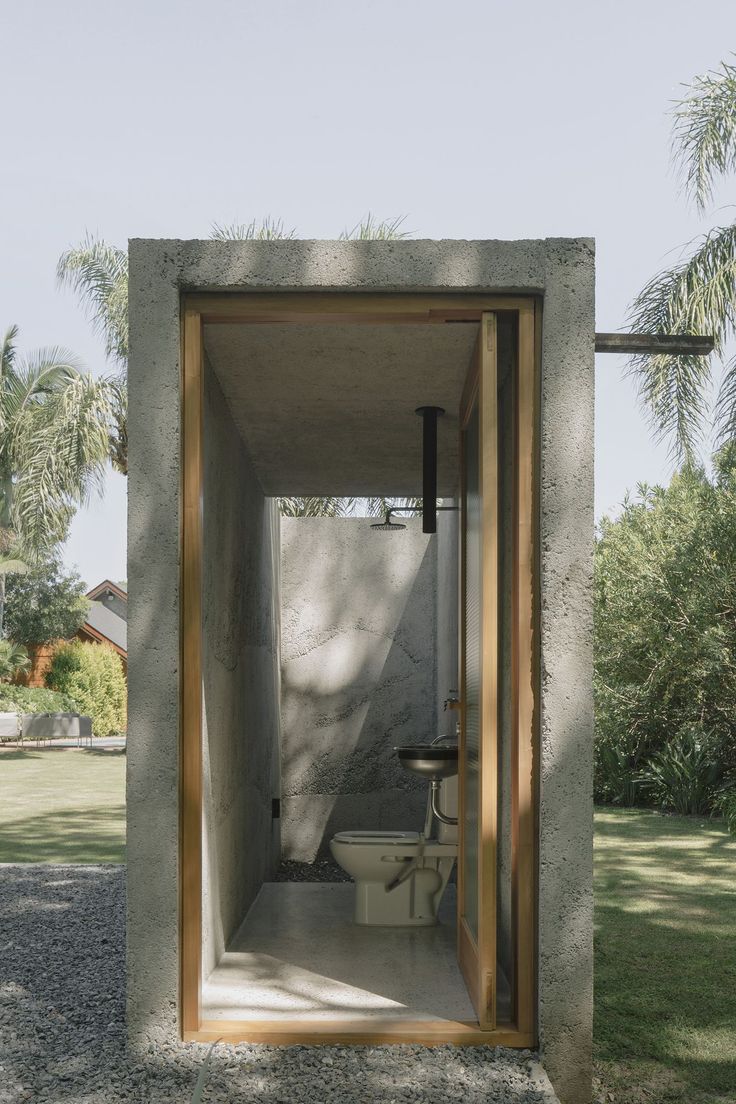 an open toilet in the middle of a concrete structure with wood trimming around it