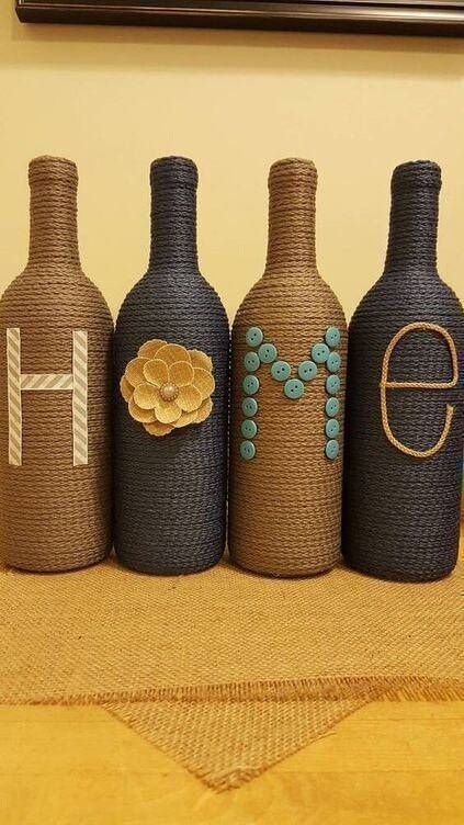 three wine bottles with the letters e, f, and h painted on them sitting on a table