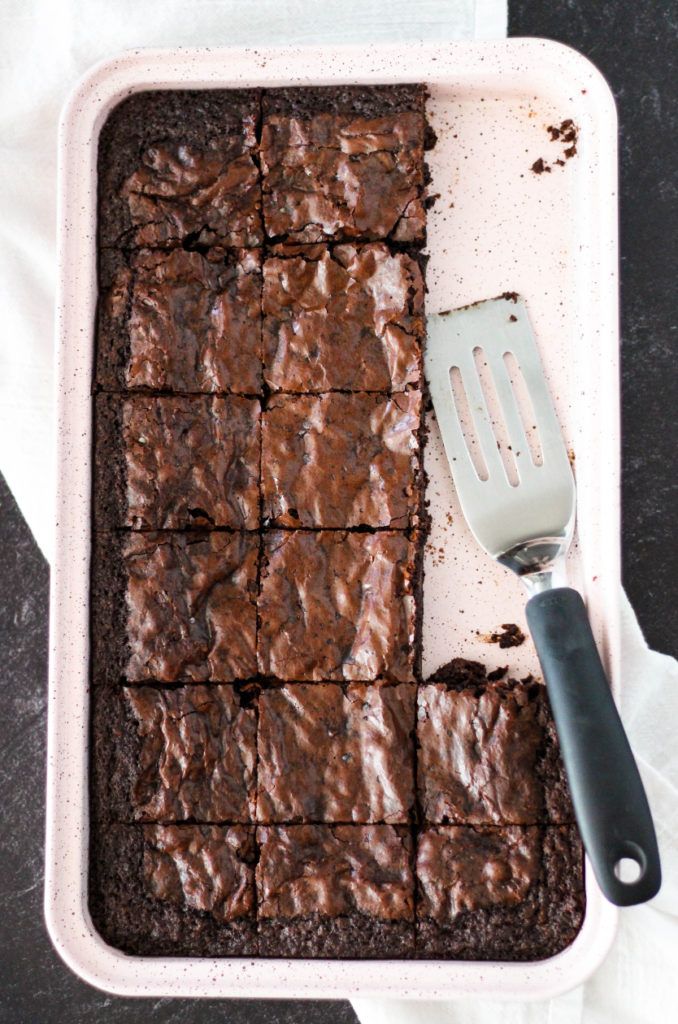 brownies in a baking dish with a spatula on the side next to it