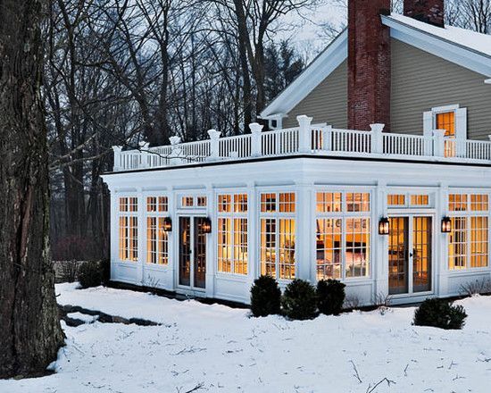 a white house with lots of windows in the front and side of it covered in snow