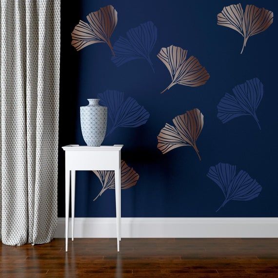 a vase sitting on top of a white table next to a blue wall