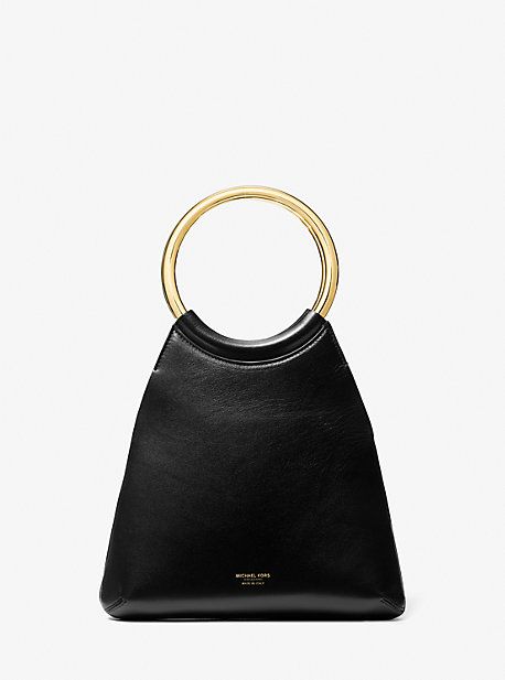 Exquisitely crafted in Italy from supple leather, the Ursula tote delivers luxury and versatility in a small package. New for Spring/Summer 2024, this style is designed in a sleek, minimalist silhouette and artfully finished with a gilded ring top handle. It looks just as chic with a daytime sundress as it does with a pantsuit after dark. Structured Bags With Gold-tone Hardware For Shopping, Modern Handheld Bucket Bag With Dust Bag, Chic Bucket Bag With Soft Leather And Round Handle, Chic Soft Leather Bucket Bag With Round Handle, Minimalist Evening Bags With Gold-tone Hardware, Everyday Bucket Bag With Gold-tone Hardware And Round Handle, Minimalist Structured Bag With Gold-tone Hardware, Modern Handheld Bucket Bag With Gold-tone Hardware, Summer Designer Bags