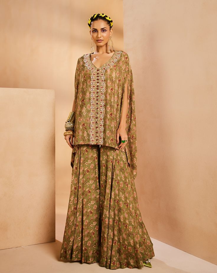 It features an easy vintage floral kaftan top with gharara pants. The kaftan has a very intricately fully hand-embroidered border panel with colorful Japanese bugle beads, sequences, and cutdana. The kaftan is accentuated with colorful bead stones.From Aneesh Agarwaal's Seher collection.DELIVERY TIMEPlease allow 8-12 weeks for your outfit to arrive.FABRIC DETAILSChinonProfessional cleaning only. Bollywood Style Embroidered Palazzo Set With Tunic, Embroidered Bollywood Palazzo Set With Tunic, Traditional Embellished Green Palazzo Set, Festive Embellished Tunic Set, Festive Green Bohemian Pant Set, Traditional Drape Pant Set With Dupatta For Reception, Bollywood Pant Set With Resham Embroidery And Traditional Drape, Bollywood Style Palazzo Set With Dupatta And Tunic, Bollywood Style Pant Set With Resham Embroidery