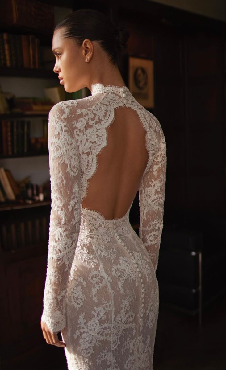 the back of a woman's wedding dress, with long sleeves and lace detailing