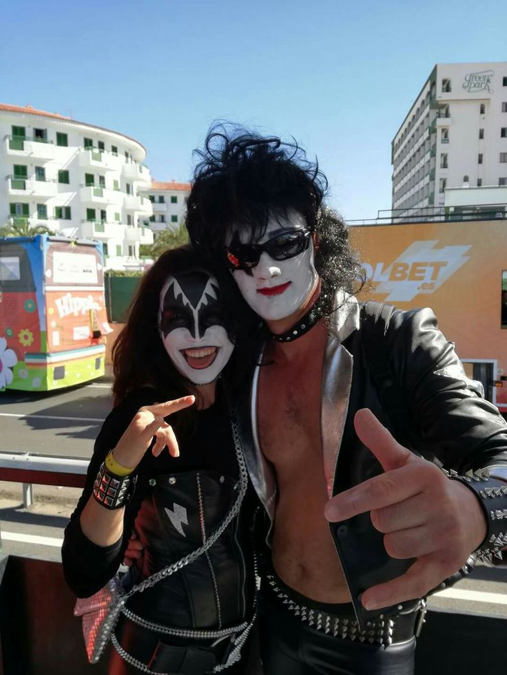 two people dressed up as kiss band members posing for the camera with their thumbs up