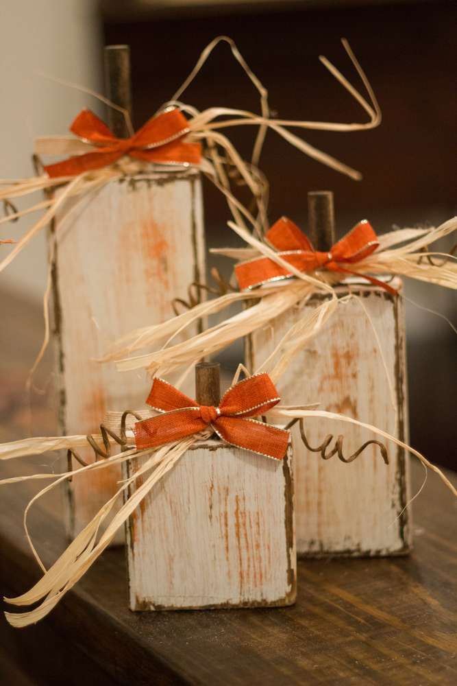 three small wooden boxes with red bows tied to them on top of a wood table