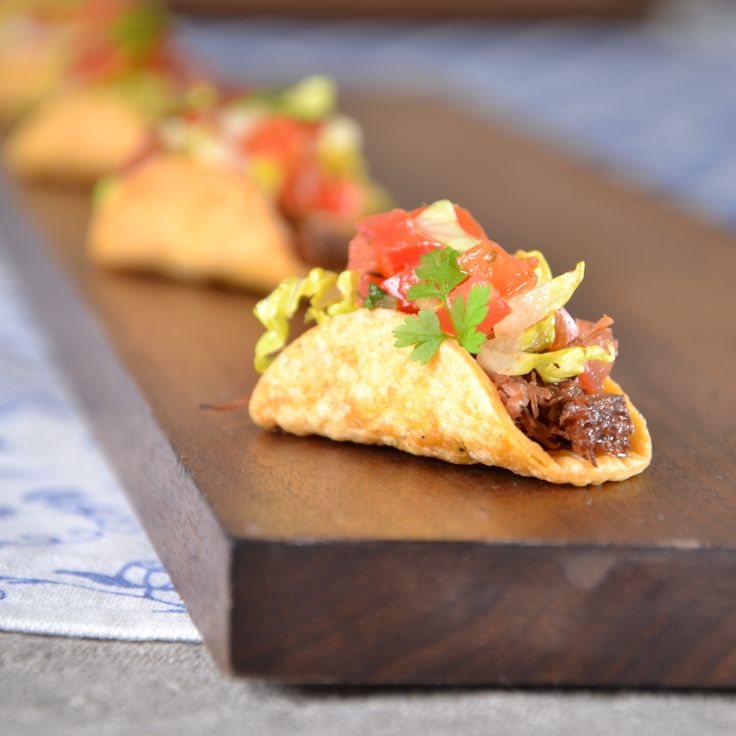 some tacos are sitting on a wooden board