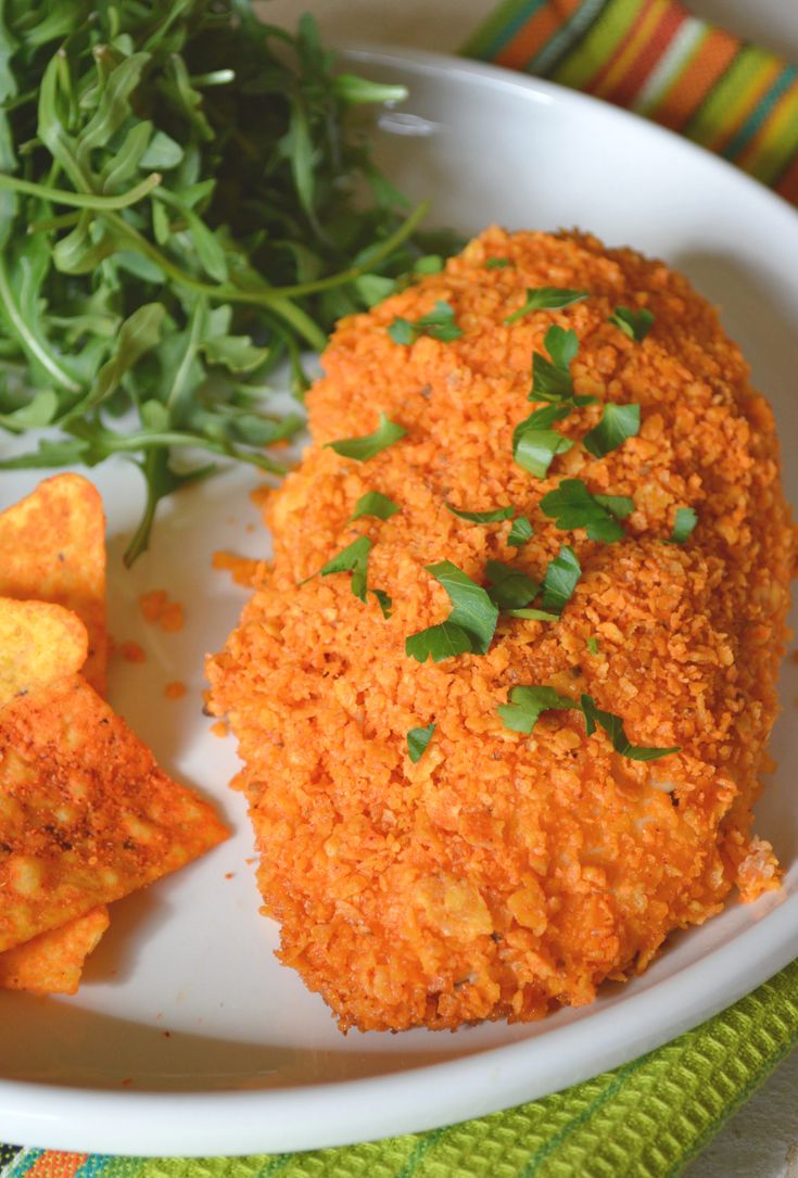 a white plate topped with fried food next to greens