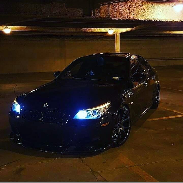 a black car parked in a parking lot at night