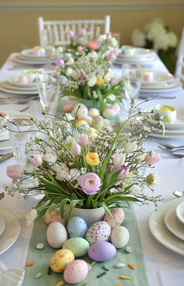 an easter table setting with flowers and eggs