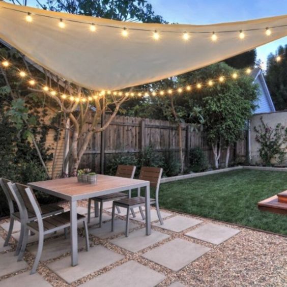 an outdoor dining area with patio furniture and string lights