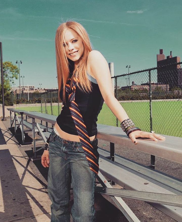 a young woman is posing on the bleachers with her hand on her hip