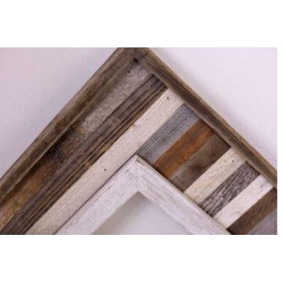 an old wooden frame hanging on the wall with white paint and brown wood grains