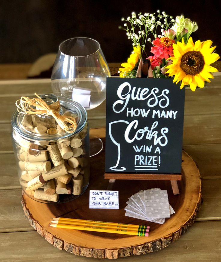 wine corks are arranged on a wood slice with a sign that says guess how many cups win a prize