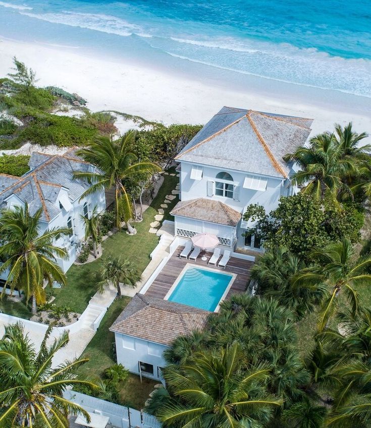 an aerial view of a house with a pool and palm trees in front of it