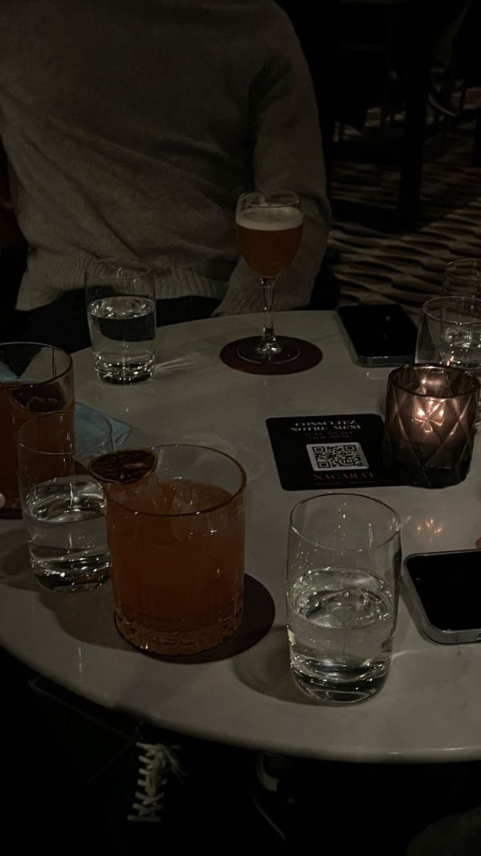 a table topped with glasses filled with different types of drinks and beverages on top of it