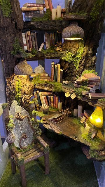 a book shelf filled with lots of books next to a chair and table covered in moss