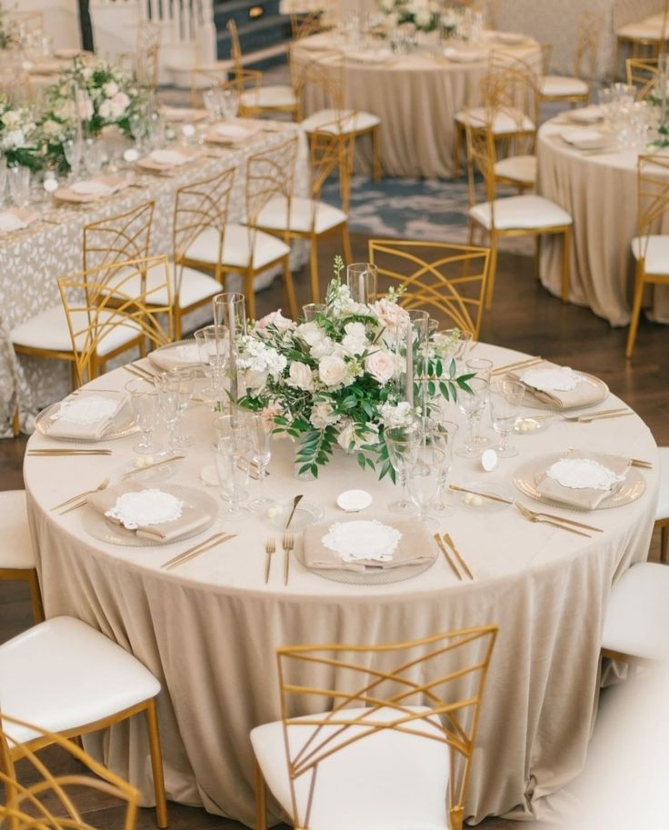 the tables are set up with white and gold linens for an elegant wedding reception