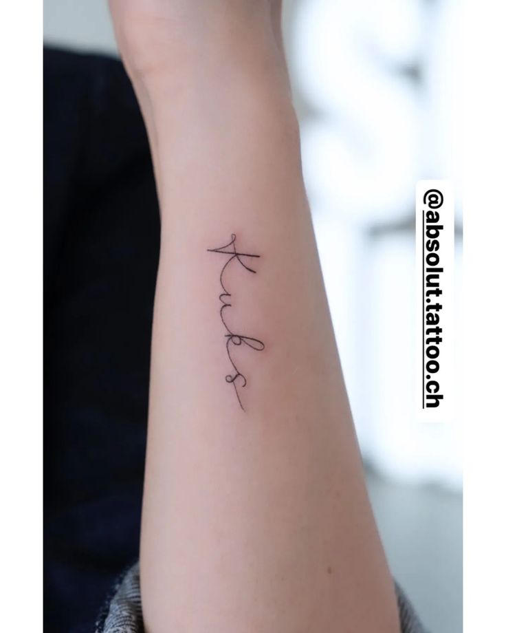 a woman's arm with a small tattoo on it