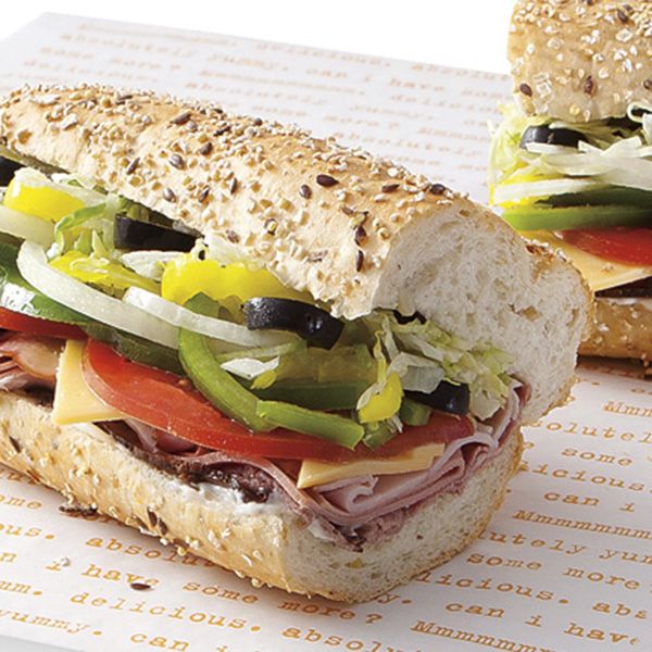 two sub sandwiches with meat, cheese and vegetables