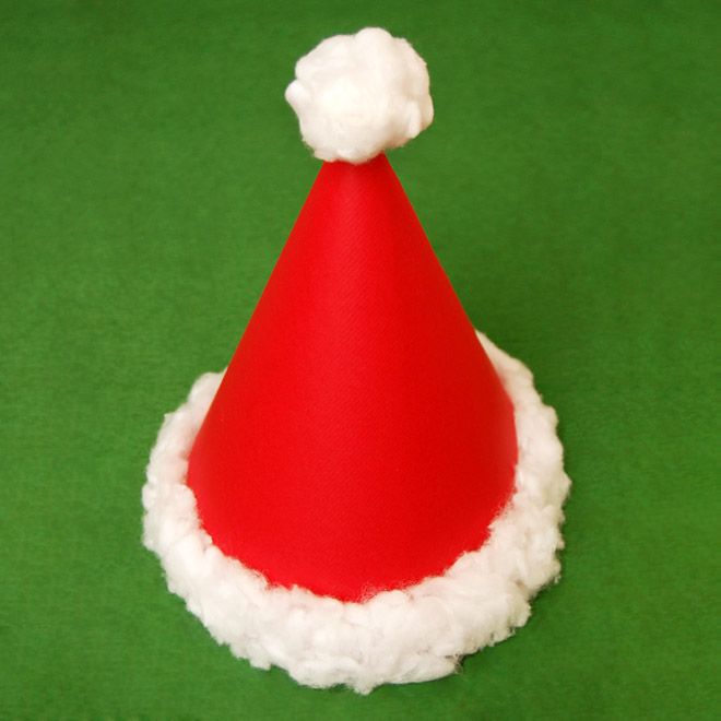 a red and white santa hat sitting on top of a green surface