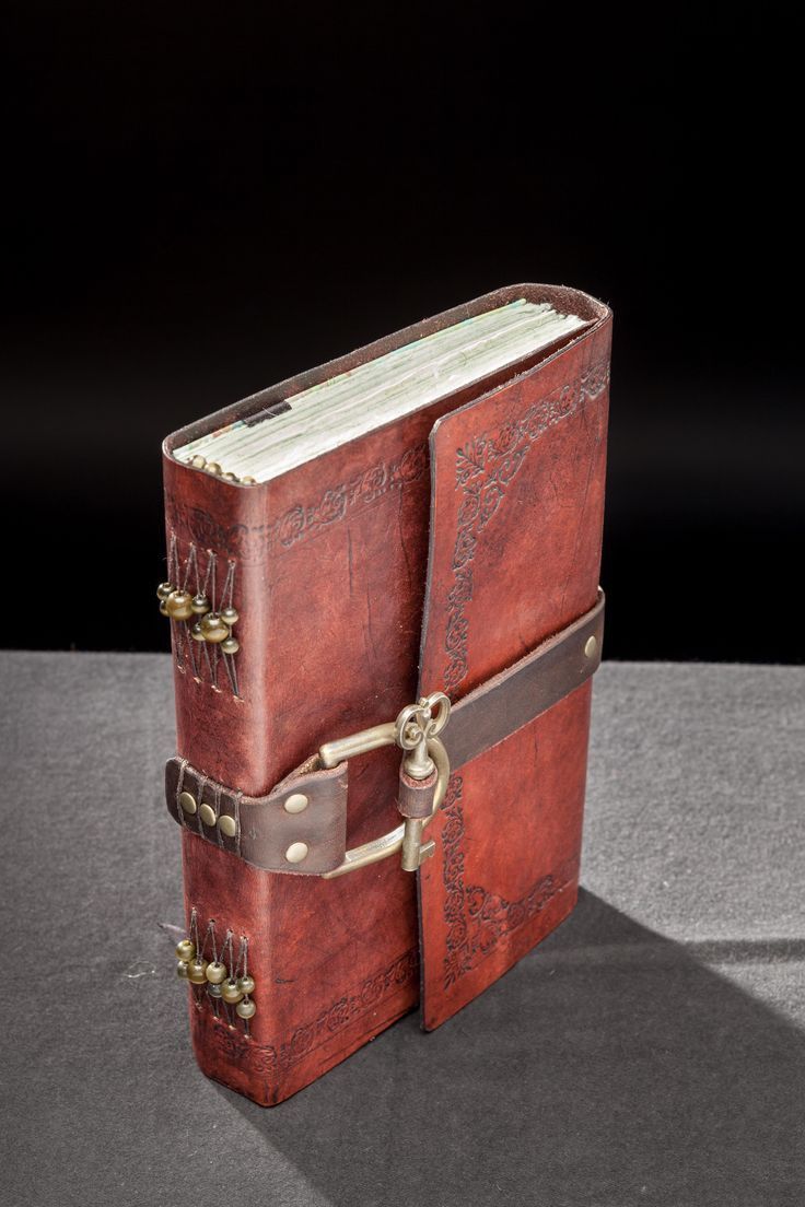 an old red leather book with two straps