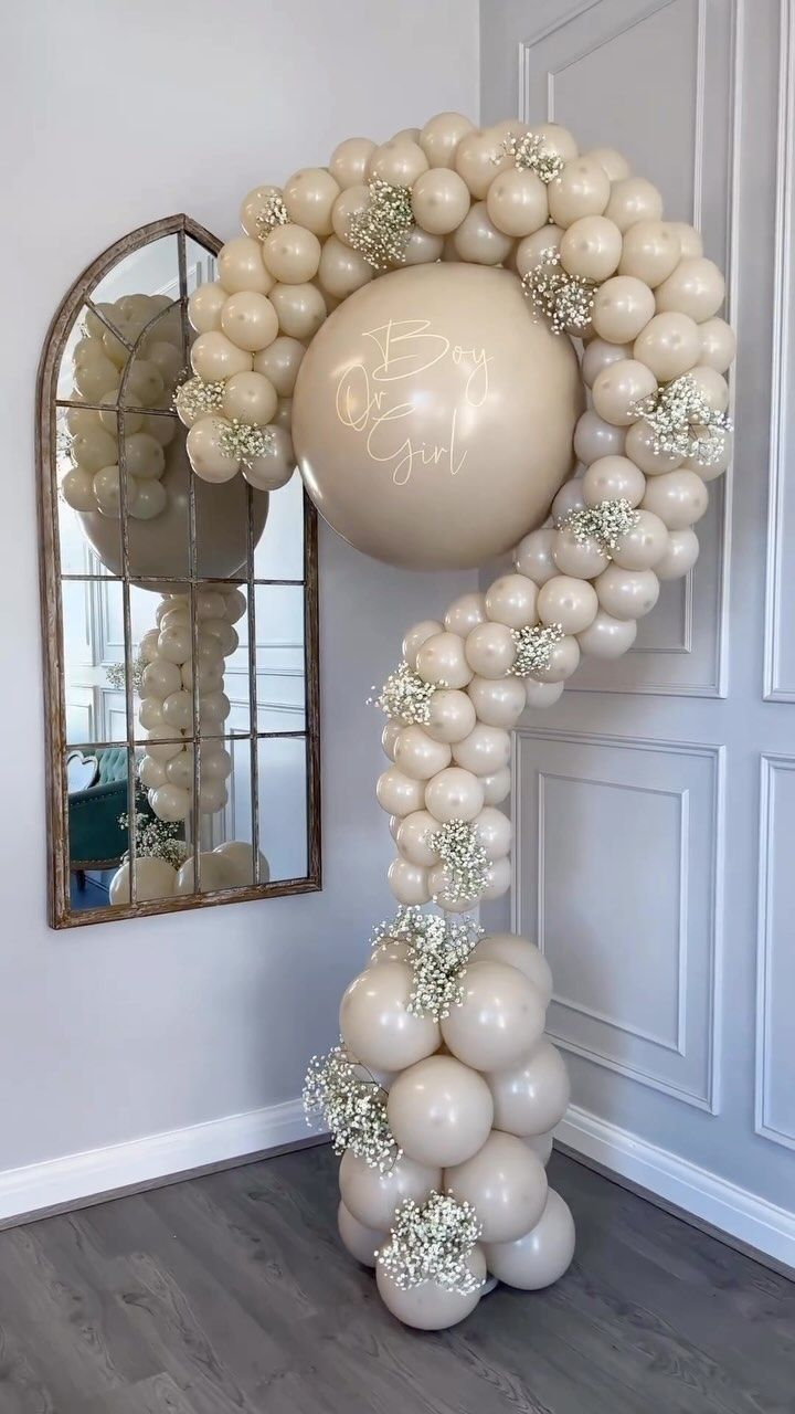 a balloon arch is decorated with white balloons