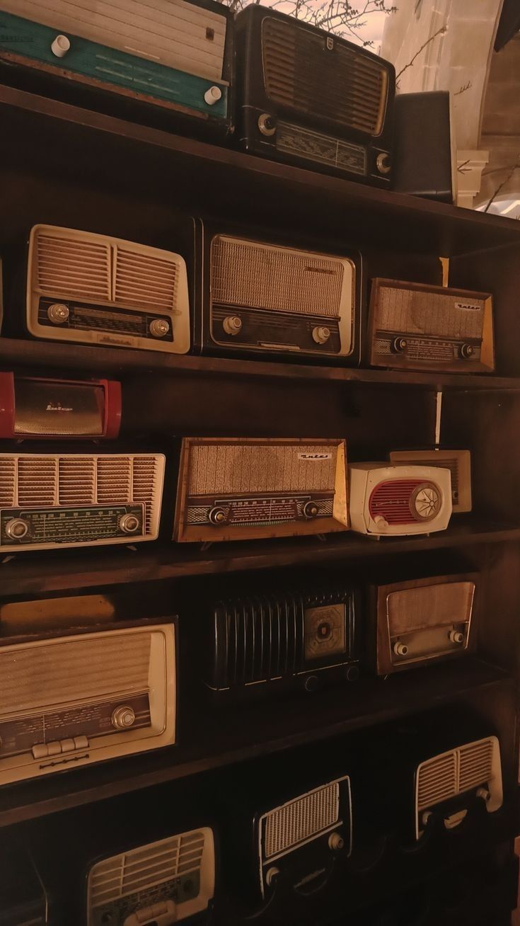 many old radio's are stacked on top of each other