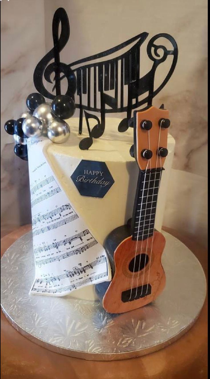 a cake decorated with musical instruments and music notes on top of a silver platter