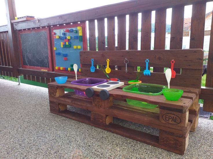 a wooden bench made out of pallets with bowls and spoons on it