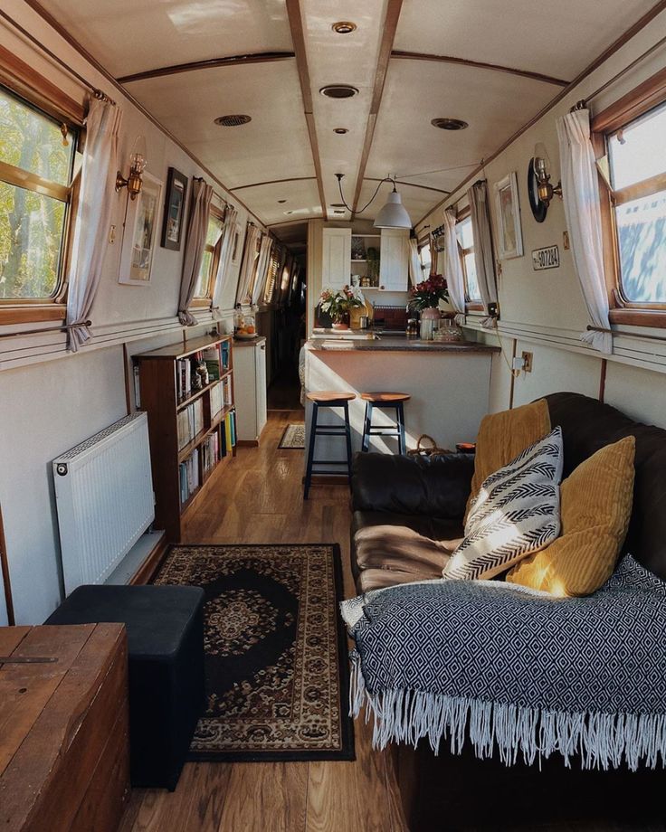 a living room with couches and tables inside of it on a wooden floor next to windows