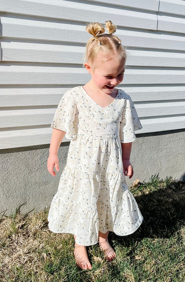 Introducing the Briggs Dress - the ultimate dreamy, flowy, and fabulous addition to your little's wardrobe! With its midi length, flowy sleeves, and v neckline, this dress is perfect for twirling around. But wait, there's more! The Briggs Dress also features a stunning floral pattern and tiered skirt detail, making it the perfect little girls dress. Dont forget to grab the adult version and match with your mini! *Relaxed fit* Material Content: Self: 100% Polyester // Lining: 100% Rayon Material Flowy Spring Twirl Dress With Flutter Sleeves, Spring Twirl Dress With Short Sleeves, Spring Short Sleeve Flowy Twirl Dress, Flowy Short Sleeve Twirl Dress For Spring, Cute Flowy Twirl Dress With Flutter Sleeves, White Spring Twirl Dress With Short Sleeves, Cute Flowy Dresses With Flutter Sleeves, White V-neck Cute Dress, Cute White V-neck Dress