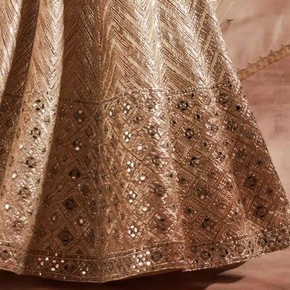 Absolute Dazzler ! A Gold organza lehenga with mirror detailing and gota work. Teamed with the most stunning blouse and a gold dupatta with mirror and gota work. Composition: Lehenga and Blouse : Organza, Dupatta - Organza All products can be customised for sleeves, length of blouse and neck design Other Details: Lining - Chroma Silk, Fastening- Concealed Zip at Blouse and Lehenga Care: Dry Clean Only and Vacuum Storage All products can be customised for colour, sleeves, length of blouse and neck design Delivery : 12 weeks as the product is hand crafted. For more information and sizes please contact fabiliciousfashion@gmail.com or visit our Copenhagen studio. Festive Tissue Silk Sharara With Gota Work, Floor-length Gota Work Sharara For Festive Occasions, Festive Anarkali Sharara With Mirror Work, Festive Floor-length Sharara With Gota Work, Festive Gota Work Floor-length Sharara, Embellished Chanderi Sharara For Navratri, Navratri Embellished Chanderi Sharara, Floor-length Mirror Work Sharara For Navratri, Floor-length Kundan Anarkali Set With Mirror Work