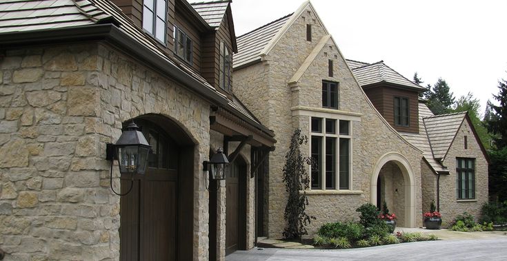 a stone house with arched windows and an entry way leading to the front door is shown