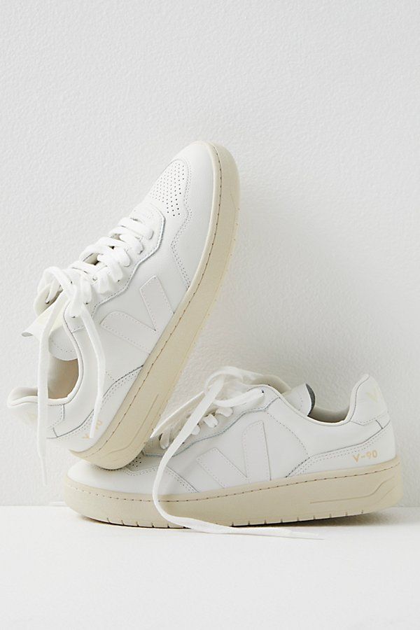 Donning a chunkier court silhouette, these low-top sneakers from Veja featured Organic Traced leather uppers complete with a perforated toe box and Amazonian rubber outsole. **Features:** Low-top style, Organic Traced leather uppers, padded collar, perforated toe box, Amazonian rubber outsole, recycled lining, lace-up closure **Why We | Veja V-90 Sneakers at Free People in White, Size: EU 39 White Veja Sneakers, Cute Running Shoes, All White Sneakers, Shoes For Work, Wedding Sneakers, Fun Shoes, Veja Sneakers, The Great White, White Sneakers Women