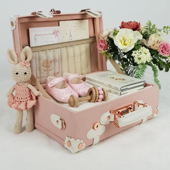 a pink suitcase with flowers and a stuffed animal in it