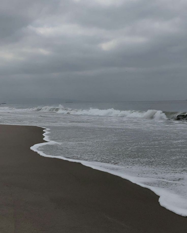 an ocean beach with waves coming in to shore