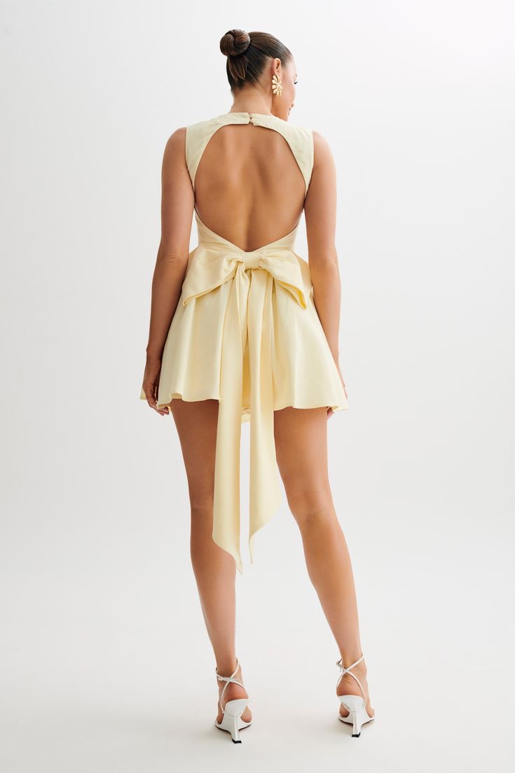 Magical daysThe MARCELLA Linen Bow Back Mini Dress features a square neckline that beautifully frames the décolletage. It includes a back functional button closure for vintage-inspired charm and ease of wear. The open back detail adds a playful twist, while front panel detailing adds texture and interest. With corset waist shaping, it enhances the figure with feminine allure. Complete with a bow back detail for a romantic finish, this dress is perfect for daytime events or casual outings. Whethe Fitted Beige Backless Dress For Summer, Summer Evening Dress With Closed Back, Summer A-line Mini Dress With Back Opening, Spring Tie Back Low Back Backless Dress, Fitted Summer Backless Dress With Bow Tie Back, Spring Tie-back Low Back Backless Dress, Spring Low Back Backless Dress With Tie Back, Chic Dress With Back Opening And Closed Back, Chic Dress With Back Opening