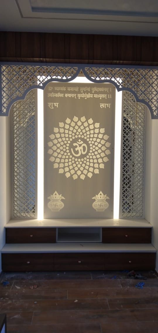 an open room with white walls and wooden flooring, decorated with intricate carvings on the wall