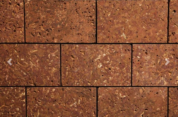 a close up of a brick wall made out of red bricks with white dots on it