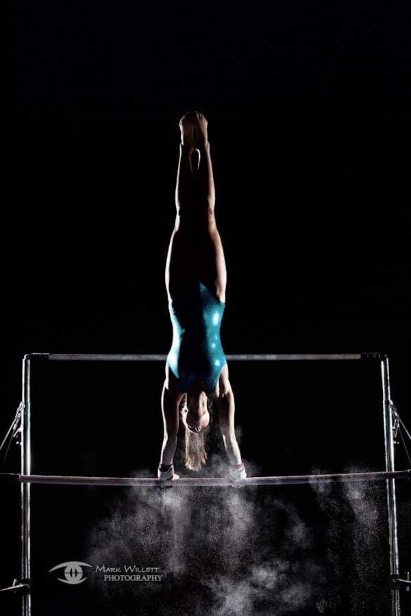 a man is doing a handstand on a trampoline in the dark